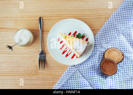 Dreieck-Käse-Kuchen im Café. Auf einem Holztisch Stockfoto