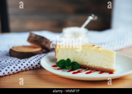 Dreieck-Käse-Kuchen im Café. Auf einem Holztisch Stockfoto