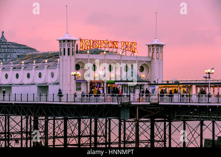 Ein wunderschöner Sonnenuntergang in der Dämmerung mit einem warmen rötlichen Ton am Brighton Pier, Brighton, England, Großbritannien Stockfoto