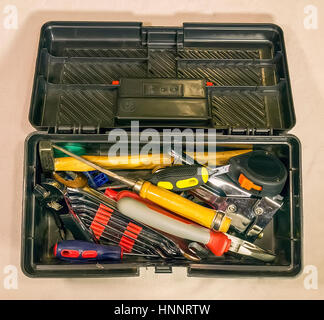 Der schwarze Toolbox mit dem Haushalt auf hellem Hintergrund Stockfoto