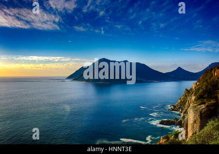 Südafrika Hout Bay Kapstadt blaue Stunde malerischen, ruhigen und romantischen Panoramablick auf die Landschaft und das Meer mit einem goldenen Sonnenuntergang über einem blauen Meer Stockfoto