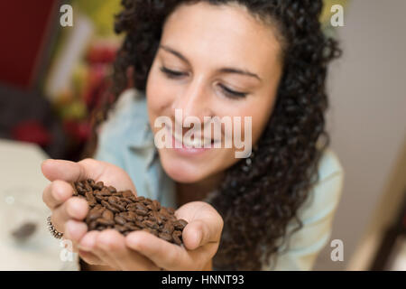 junge Frau mit einigen Kaffeebohnen in der hand Stockfoto