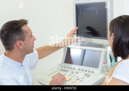 Arzt mit Utrasound Bildschirm für Patienten Stockfoto