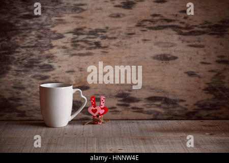 Tasse Kaffee und Herz mit Liebe auf dem alten Holzboden. Stockfoto