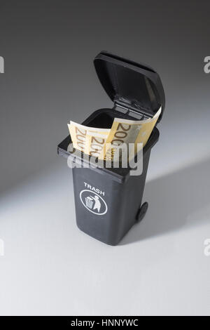 200 Euro-Banknoten/Rechnungen in einem Spielzeug-Fach auf Rädern/Schubfach/Papierkorb. Metapher für das Verschwenden von Geld, Geld im Ablass. Stockfoto