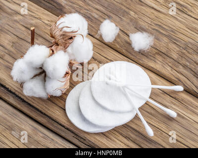 Flauschige Wattebausch und Wattestäbchen und Pads auf Holztisch. Stockfoto