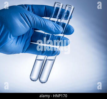 Labor-Becher in der Hand des Analytikers in Kunststoff-Handschuh. Stockfoto