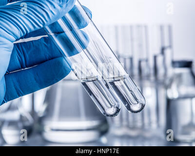 Labor-Becher in der Hand des Analytikers in Kunststoff-Handschuh. Stockfoto