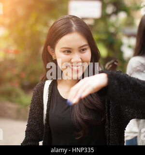 Frau genießen Schmetterling thront auf ihrer Hand im park Stockfoto