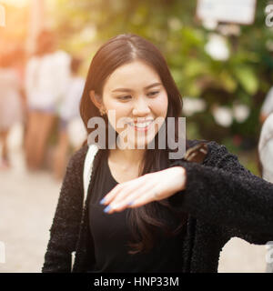 Frau genießen Schmetterling thront auf ihrer Hand im park Stockfoto