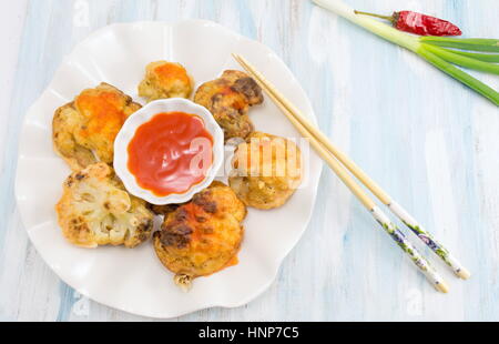 paniert Gebratener Blumenkohl mit Stäbchen und Ketchup auf einem Teller Stockfoto