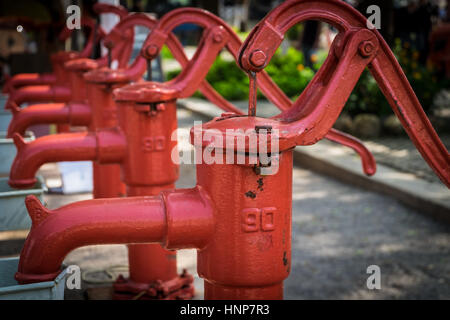 Rote Hand Wasserpumpen vorne konzentrieren. Stockfoto