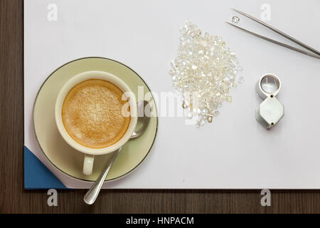 Kaffee, Diamanten, Lupe und Pinzette Stockfoto