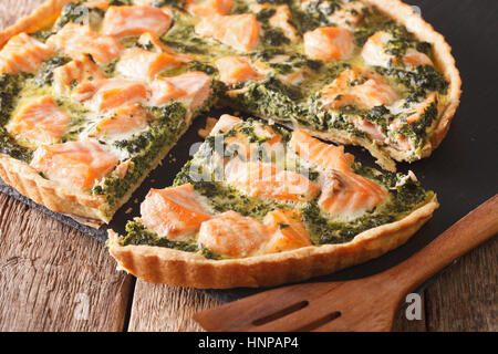 in Scheiben geschnitten herzhafte Quiche mit Lachs und Spinat, close-up auf dem Tisch. Horizontale Stockfoto