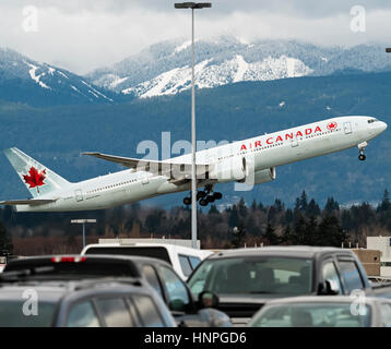 Air Canada Flugzeug Boeing 777 (777-300ER) ausziehen hinter einem Parkplatz im freien Vancouver International Airport Stockfoto