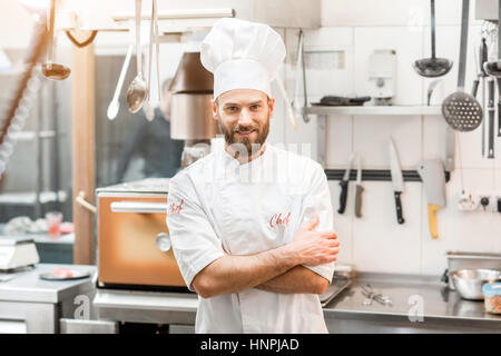 Porträt von Chef-Koch in Uniform in der Restaurantküche Stockfoto