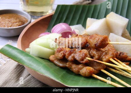Chicken Satay. Beliebte Grillgut in Singapur und Malaysia, serviert mit Erdnuss-Sauce, Reis, Kuchen, Gurke und Schalotten. Stockfoto