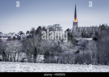 St. Marys Church leuchtet in der frühen Morgensonne, wie die ersten leichte Abstauben von Schnee die Cotswold Stadt von Tetbury, Gloucestershire trifft. Stockfoto