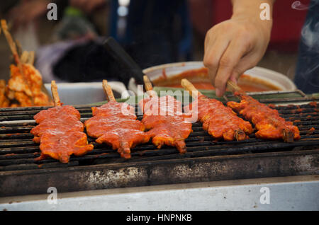 Thais Kochen gegrilltes würziges Huhn mit curry des südlichen in Thailand genannt Kai Ayam Golek oder Gai Golek zum Verkauf auf Markt Stockfoto