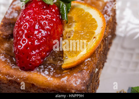 Stück Kuchen mit Erdbeeren und Zitrone auf Untertasse Stockfoto