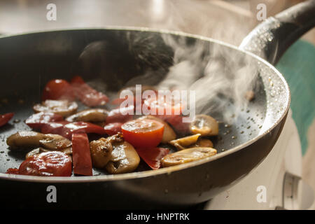 Pilze & Tomaten in einer Pfanne braten Stockfoto