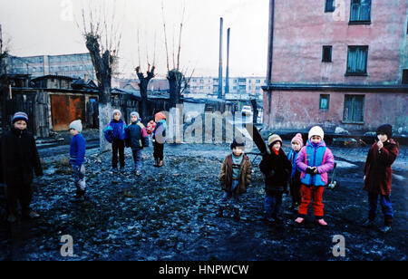 Kinder von der siebenbürgischen Bergbau Stadt der Kohlegruben in Rumänien spielen gerne im Schlamm und Müll übersäten Straßen - Foto von Simon Dack Dezember 1994 Stockfoto