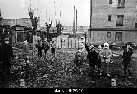 Kinder von der siebenbürgischen Bergbau Stadt der Kohlegruben in Rumänien spielen gerne im Schlamm und Müll übersäten Straßen - Foto von Simon Dack Dezember 1994 Stockfoto