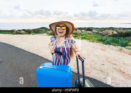 Reisen, Urlaub, Sommer und Urlaub Konzept - ist junge Frau stehen und Lachen mit Koffern unterwegs Stockfoto