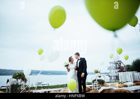 schöne junge Hochzeit paar küssen, blonde Braut mit flowe Stockfoto