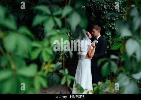 schöne junge Hochzeit paar küssen, blonde Braut mit flowe Stockfoto