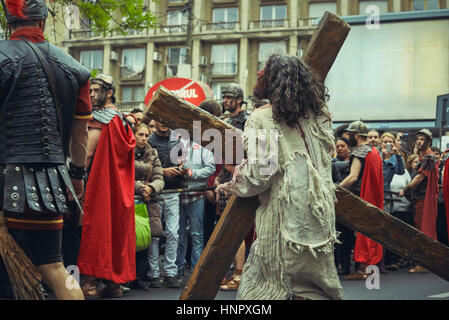 Schauspieler spielt erschöpft Jesus Christus mit großen Holzkreuz während die Nachstellung des Kummers Weg am 15. April 2014, Bukarest, Rumänien Stockfoto
