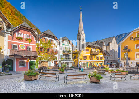 Malerische Postkartenblick auf den historischen Stadtplatz von Hallstatt mit traditionellen bunten Häusern und einer Kirche am Hallstätter See in den Alpen, Österreich Stockfoto