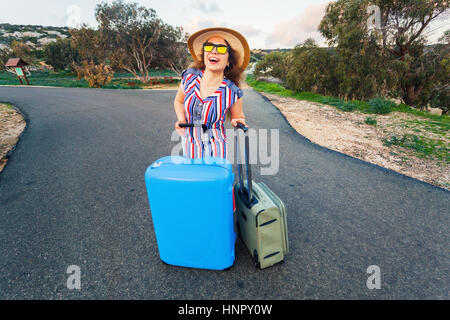 Reisen, Urlaub, Sommer und Urlaub Konzept - ist junge Frau stehen und Lachen mit Koffern unterwegs Stockfoto