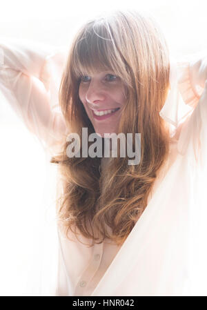 Eine Frau in eine reine Bluse mit langen roten Haaren Stockfoto