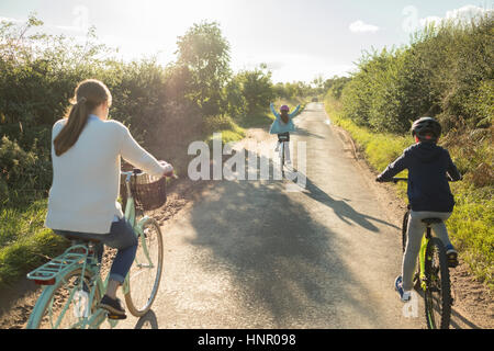 Eine Familie Radtour mit Mutter und zwei Kindern auf dem Lande. Stockfoto