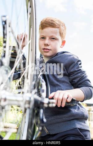 Ein Junge sein Fahrrad Pflege Stockfoto