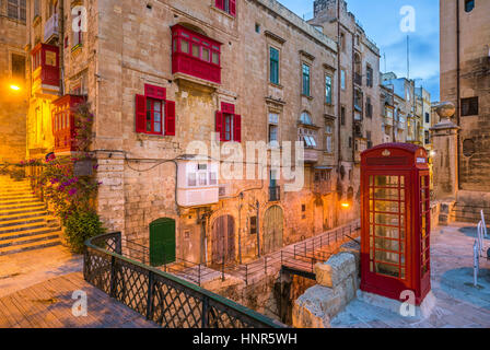 Valletta, Malta - rote Vintage britische Telefonzelle und Steg und traditionellen roten Balkonen in der antiken Stadt Valletta in den frühen Morgenstunden Stockfoto