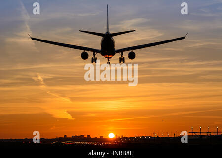 Passagierflugzeug ist in einem wunderschönen Sonnenaufgang landen. Das Flugzeug ist fast auf der Start-und Landebahn gelandet. Stockfoto