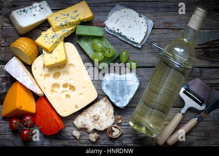 Verschiedene Arten von Käse mit Flasche Wein am alten Retro-Bretter-Stillleben Stockfoto