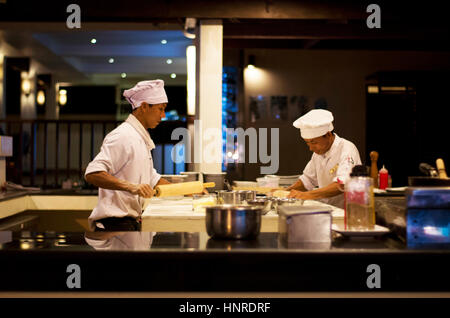 Köche, die Zubereitung von Speisen in der offenen Küche in einem Straße Restaurant auf Koh Chang in Thailand. Stockfoto