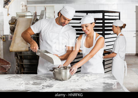 Männliche und weibliche Bäcker in der Bäckerei arbeiten zusammen Stockfoto