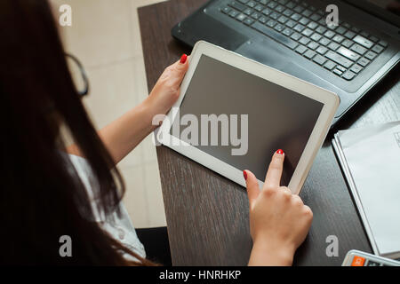 Weibliche Buchhalter Händen mit tablet-pc. Tabelle mit Laptop auf Hintergrund Stockfoto