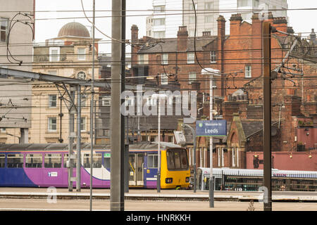 Leeds Stadtbild.  Leeds-Bahn Bahnhof Bahnsteig mit Oberleitungen, und typische Gehäuse und Baustile hinter Stockfoto