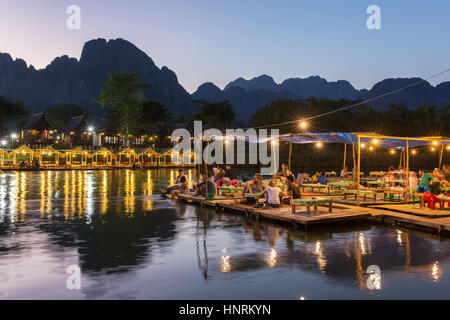 Vang Vieng, Laos - 19. Januar 2017: Restaurant am Flussufer während des Sonnenuntergangs in Vang Vieng, Laos Stockfoto