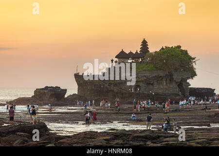 Bali, Indonesien - 23. Juli 2016: Touristen zu Fuß in der Nähe von Tanah Lot Tempel während des Sonnenuntergangs in Bali, Indonesien Stockfoto