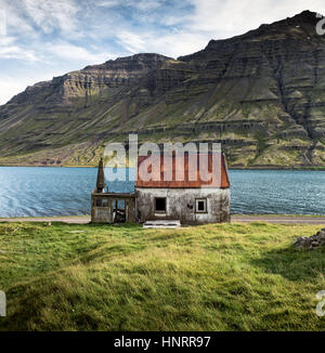 Verlassene Fjordland Haus mit ein leuchtend rotes Dach in Seydisfjordur, Ost-Island Stockfoto