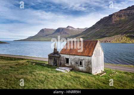 Verlassene Fjordland Haus mit ein leuchtend rotes Dach in Seydisfjordur, Ost-Island Stockfoto