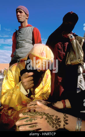 Frau Anwendung eine Henna-Tattoo auf eine Touristen-Hand im Markt Djemaa el-Fna in Marrakesch Marokko Stockfoto