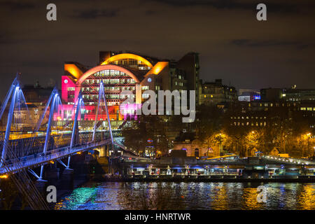 Nachtansicht über die Themse auf der beleuchteten Golden Jubilee Bridge und Charing Cross Station, London Stockfoto