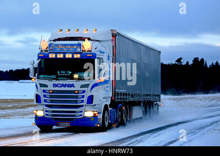 SALO, Finnland - 7. Januar 2017: Sattelauflieger maßgeschneiderte Super Scania T. Salminen Verkehr bewegt sich auf verschneiten Autobahn bei Dusktime im Süden von Finla Stockfoto